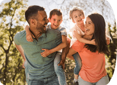 couple smiling with their children on their backs